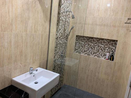 a bathroom with a sink and a shower at Omah Tabon Jogja - Dekat Dengan Malioboro in Timuran