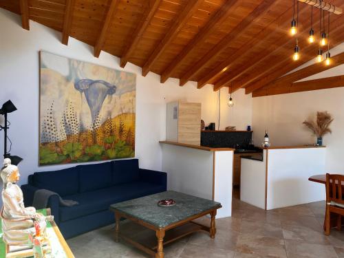 a living room with a blue couch and a painting on the wall at Pilgrims Rest - Vila Nova de Cerveira - Hostel - Albergue - AL in Vila Nova de Cerveira
