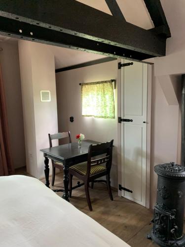 um quarto com uma mesa, uma cadeira e uma cama em Bed and Breakfast Bakrust, met privé sauna Putten em Putten