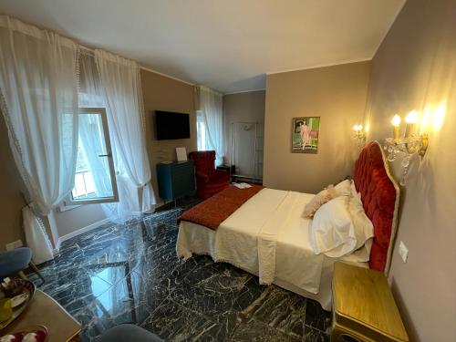 a bedroom with a bed and a chair in a room at Prestige Suite Via Romagnoli in Sirmione