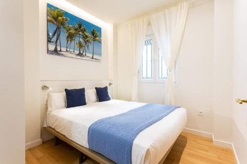 a bedroom with a bed with a blue and white blanket at Holidays2Malaga Victoria 40 Quiet & Central in Málaga