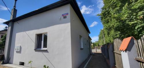 Casa blanca con ventana y valla en Noclegi Tuszyn, en Tuszyn