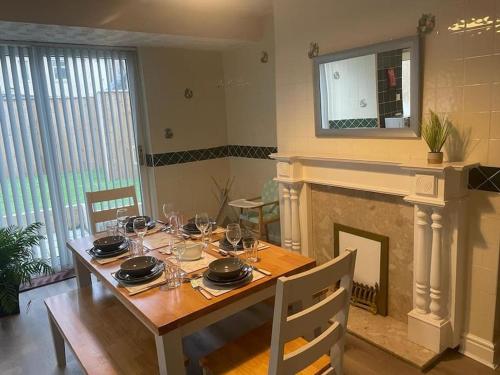 een eetkamer met een tafel en een open haard bij Lovely 3 bedroom house with off street parking in Thornton