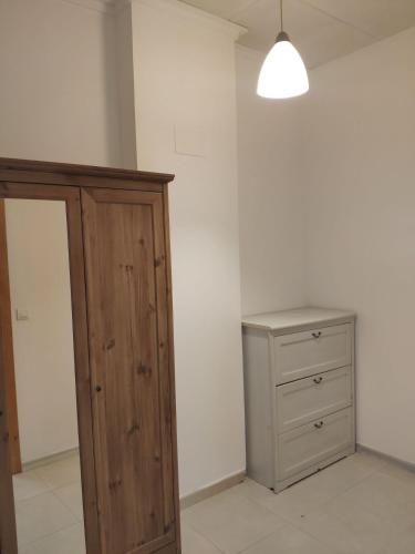 a bedroom with a wooden cabinet and a dresser at l4 in Santiponce