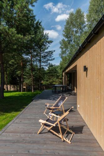 two lounge chairs sitting on a sidewalk next to a building at POINT WARMIA in Cerkiewnik