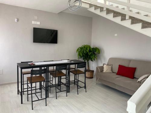 ein Wohnzimmer mit einem Tisch, Stühlen und einem Sofa in der Unterkunft MeraviglioSalento in Squinzano