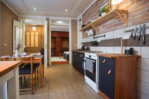 a kitchen with a table and a dining room at Hygge Home Apartman in Eger