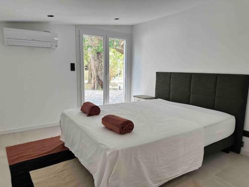 une chambre avec un lit avec deux oreillers dessus dans l'établissement Villa la Guinguette sous les Mûriers - Box gourmande - Piscine - Clim, à Perpignan