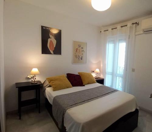 - une chambre avec un lit, 2 tables et 2 lampes dans l'établissement Bonito apartamento en centro, à Malaga