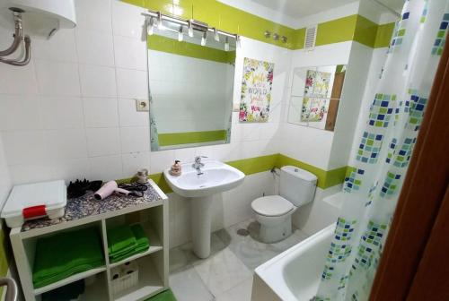 La salle de bains est pourvue d'un lavabo, de toilettes et d'un miroir. dans l'établissement Bonito apartamento en centro, à Malaga