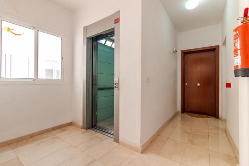 a hallway with a door and a window at Flatguest La Herradura in Telde