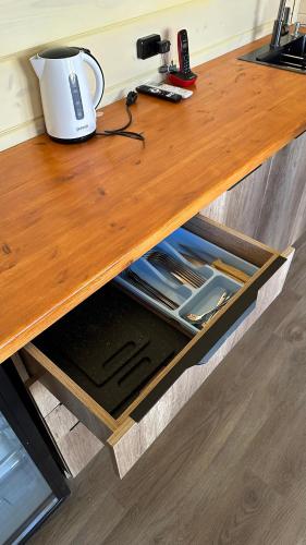 a wooden desk with a coffee maker on top of it at Гостинично-банный комплекс PARADISE in Shchūchīnsk