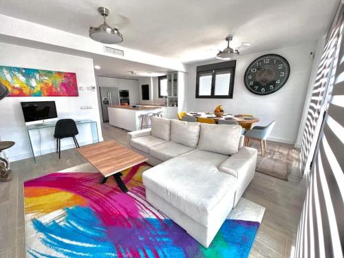 a living room with a white couch and a colorful rug at Acogedora casa en Madrid con piscina privada, jacuzzy y garaje in Madrid