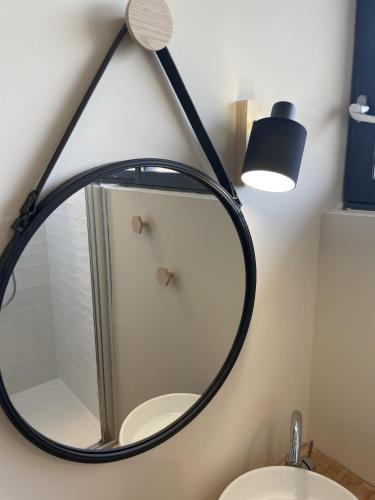 a bathroom with a mirror and a lamp on the wall at Côté Nuit in Capestang
