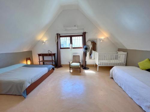 a attic bedroom with two beds and a window at Villa Isabella in Trou dʼ Eau Douce