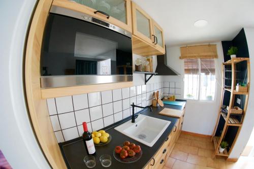 a kitchen with a sink and a bowl of fruit on a counter at "soñaC soL" in Los Caños de Meca