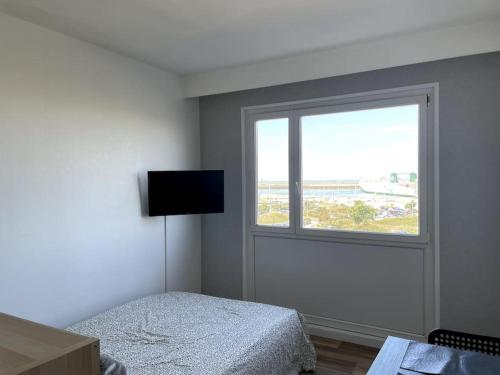 a bedroom with a bed and a window at Studio Horizon Bleu, vue mer in Calais