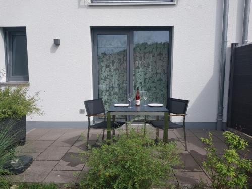 a table with two chairs and a bottle of wine at Ferienwohnung Markert - Neben den Weinbergen in Randersacker