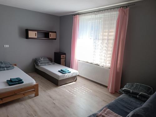 a small room with two beds and a window at Parkowe Ranczo in Poraj