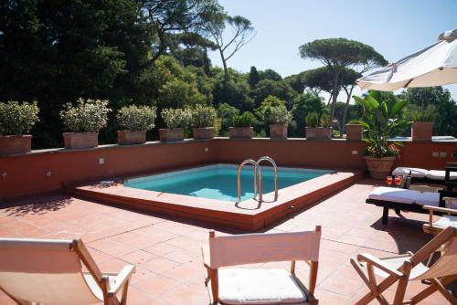 a swimming pool in a patio with chairs and an umbrella at Villa Terme di Caracalla with private Swimming Pool in Rome