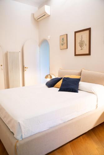 a bedroom with a large white bed with blue pillows at Villa Terme di Caracalla with private Swimming Pool in Rome
