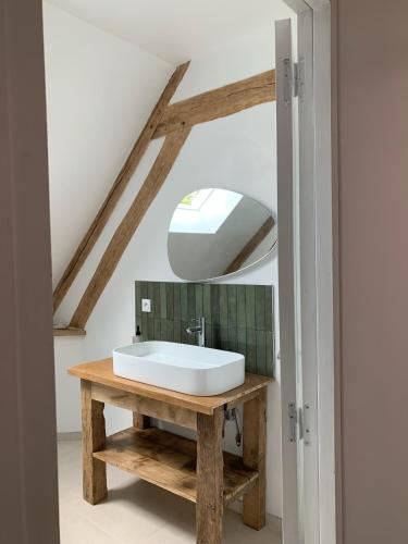 une salle de bain avec un lavabo et un miroir dans l'établissement Cottage au cœur du Perche, à Souancé-au-Perche