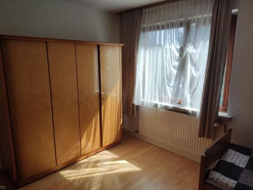 a room with a wooden cabinet and a window at Unterkunft Mau in Rotenburg an der Wümme