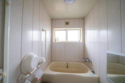 a bathroom with a tub and a toilet and a sink at Ota Building - Vacation STAY 13994 in Otaru