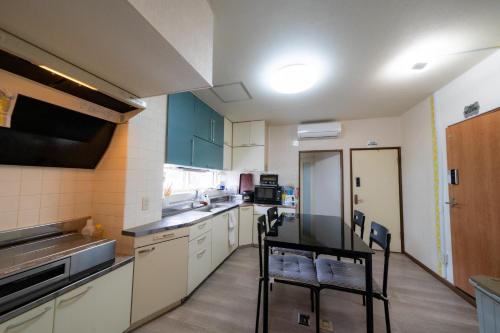 a kitchen with a counter and chairs in it at Ota Building - Vacation STAY 13991 in Otaru