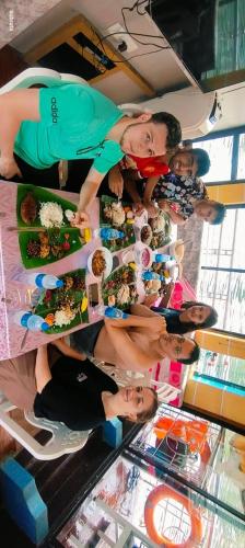 a group of people standing around a table with food at Beach Paradise Day Cruise Houseboat in Alleppey