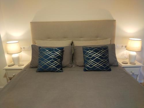 ein Bett mit blauen Kissen und zwei Lampen in der Unterkunft Apartament Les Cases in Les Cases d'Alcanar