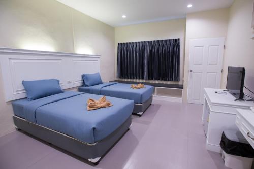 1 dormitorio con 2 camas, TV y escritorio en Diamond Hill Resort, en Nong Nam Daeng