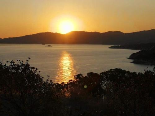 a sunset over a body of water with the sun setting at Casa vacanze il Pastore Tedesco in Portoferraio