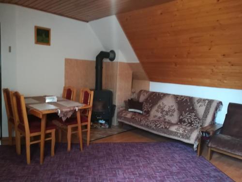 a living room with a table and a wood stove at Privát Erika in Liptovský Ján