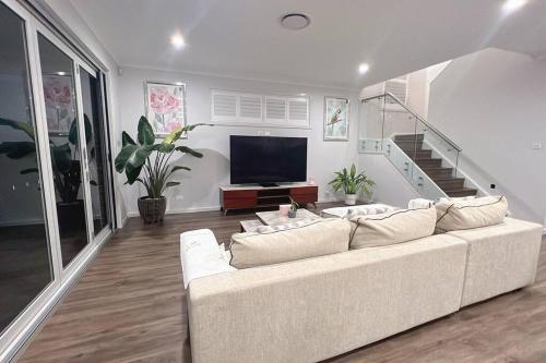 a living room with a white couch and a flat screen tv at 7 Aurora Ave Dunmore in Dunmore