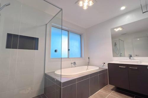 een badkamer met een bad, een wastafel en een spiegel bij 7 Aurora Ave Dunmore in Dunmore