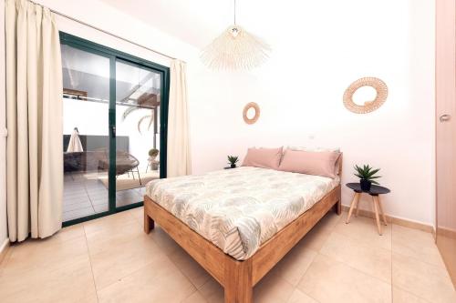 een slaapkamer met een bed en een balkon bij Casa Costa Esmeralda Plus-Pool and Relax in Costa Teguise