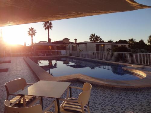 einen Pool mit einem Tisch und Stühlen neben einem Haus in der Unterkunft VILLAMÓNICA in Torrellano