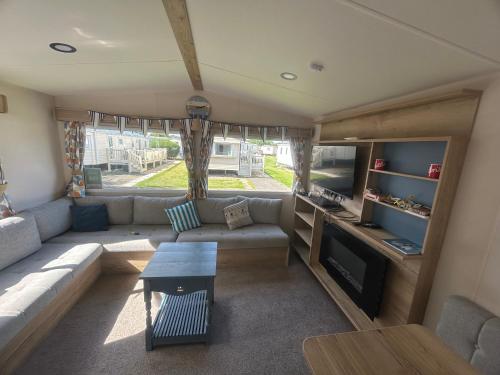 een woonkamer met een bank en een tafel bij Butlins Skegness Caravan in Lincolnshire
