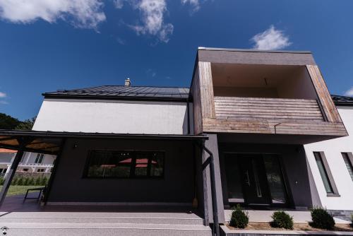 una casa en blanco y negro con techo en Cabana 1407 Valea Avrigului, en Avrig