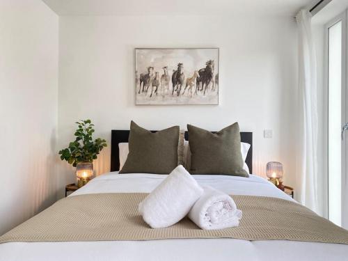 埃普瑟姆的住宿－Epsom Modern Luxury 1 Bed Apartment with Extra Sofa Bed - East Street，一间卧室配有一张床,上面有两条毛巾