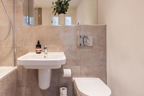 a bathroom with a sink and a toilet at Epsom Modern Luxury 1 Bed Apartment with Extra Sofa Bed - East Street in Epsom