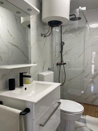 a bathroom with a white sink and a toilet at Guesthouse Davorka Bijelić in Murter