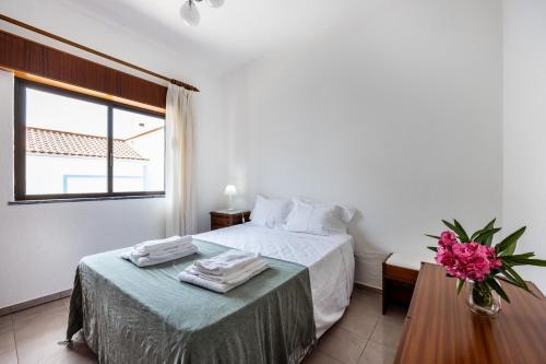 a bedroom with a bed and a table with towels on it at Alagoa Apartment in Altura