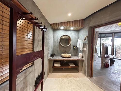 bagno con lavandino e specchio di Moganshan 107 Courtyard B&B a Deqing
