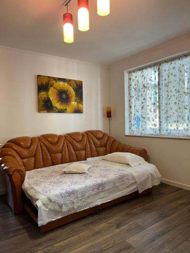 ein Schlafzimmer mit einem Lederbett in einem Zimmer mit einem Fenster in der Unterkunft Cazare David si familia . in Piatra Neamţ