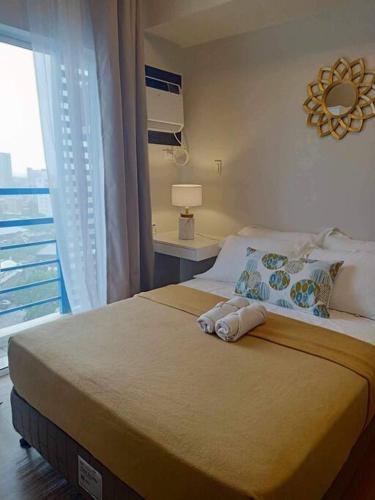 sypialnia z dużym łóżkiem i oknem w obiekcie Studio with Balcony at The Loop Tower w mieście Cagayan de Oro