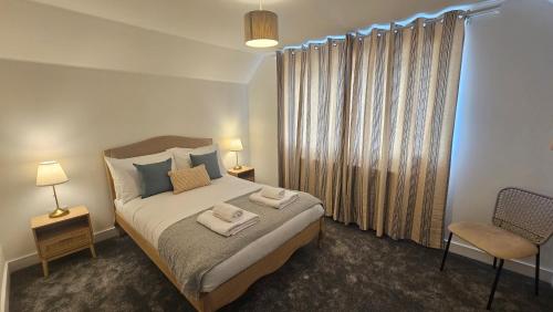 a bedroom with a bed with two towels on it at The Oasis, SAV - Romney Sands Beach House in Littlestone-on-Sea
