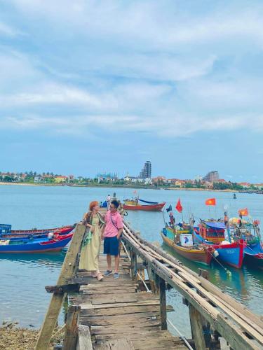 two women standing on a wooden pier with boats at HAI DANG HOTEL in Xóm Ðé