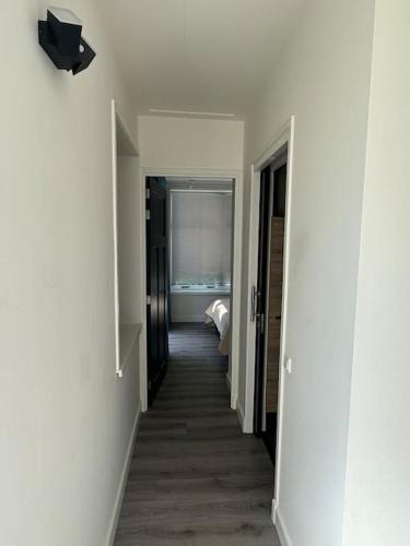 un corridoio che conduce a una camera con pareti bianche di Golfbaan om de hoek! a Nieuwveen